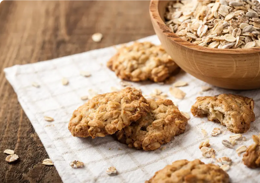 A plate of freshly baked oatmeal cookies next to a bowl of creamy oatmeal, showcasing a cozy breakfast setting