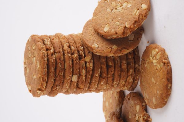 A-close-up-of-a-stack-of-honey-oat-cookies-on-a-white-background-emphasizing-their-warm-color-and-rustic-texture