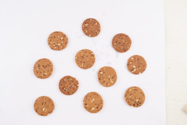 A-multigrain-cookie-cutter-and-a-cookie-sheet-placed-on-a-white-surface-ready-for-baking