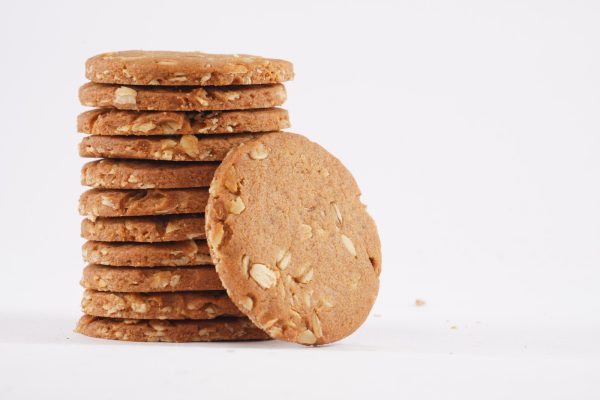 A-neatly-arranged-stack-of-honey-oat-cookies-against-a-white-background-highlighting-their-inviting-appearance
