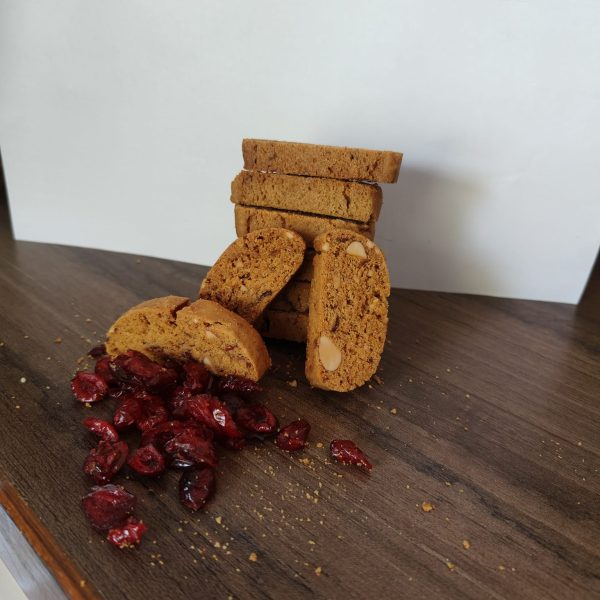 A-pile-of-cranberry-biscotti-cookies-and-fresh-cranberries-arranged-on-a-wooden-table