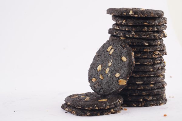 A-stack-of-dark-chocolate-oat-cookies-topped-with-seeds-showcasing-a-delicious-and-healthy-treat