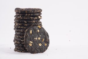 A-tower-of-dark-chocolate-oat-cookies-adorned-with-seeds-highlighting-a-tasty-and-nutritious-snack-option