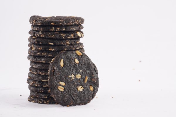 A-tower-of-dark-chocolate-oat-cookies-adorned-with-seeds-highlighting-a-tasty-and-nutritious-snack-option