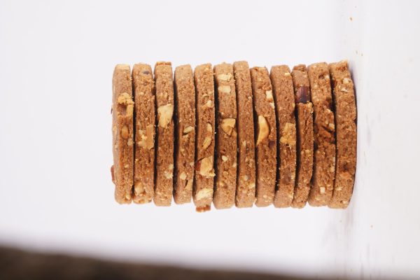 A-white-background-features-a-stack-of-crispy-almond-cookies-showcasing-their-texture-and-color